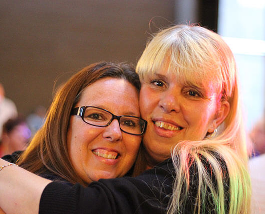 Awards Ceremony two attendees hugging